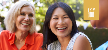 Two women sitting outside and smiling