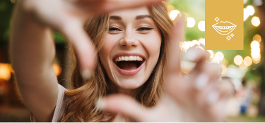 Blonde woman laughing and making frame with fingers